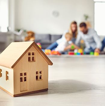 Small home model with family in the background.