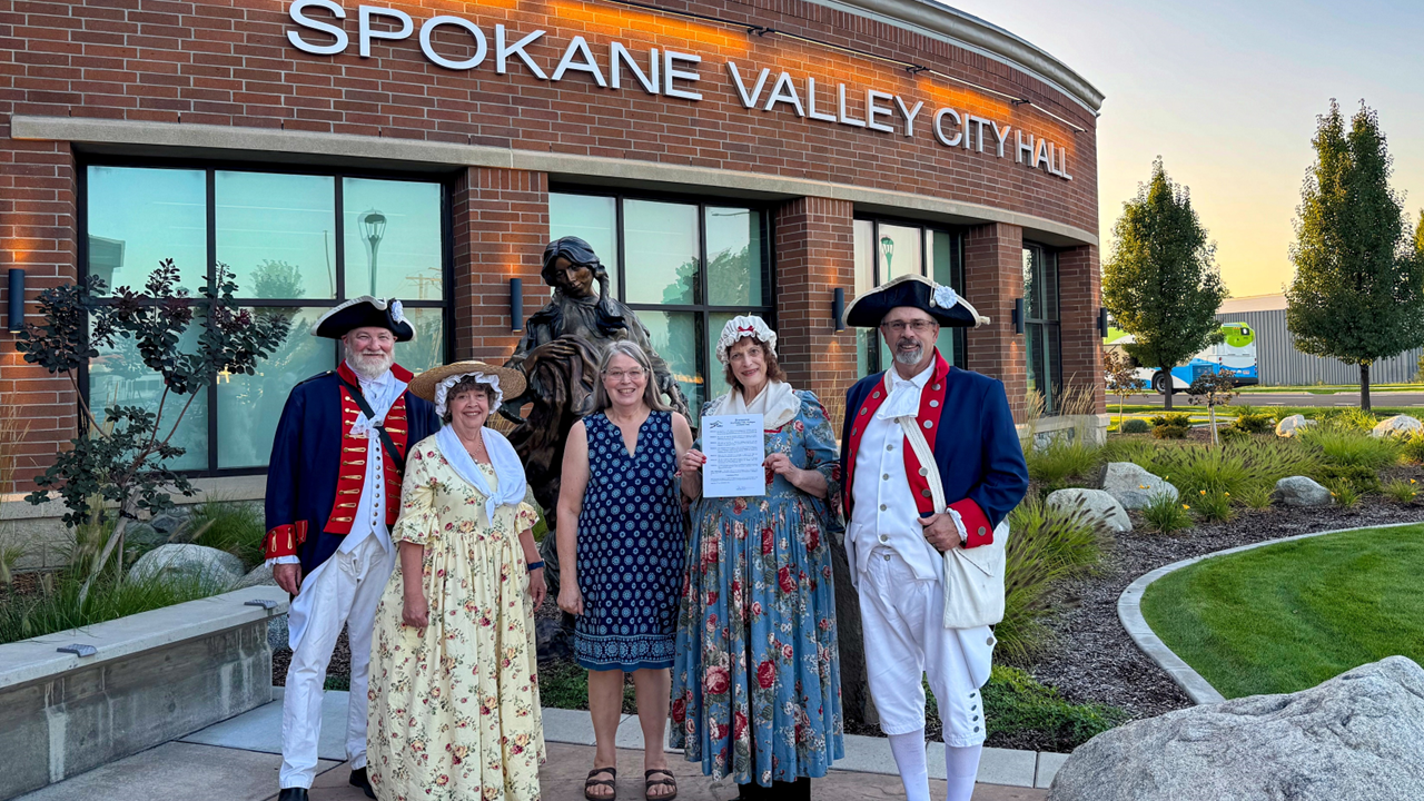 The Sons and Daughters of the American Revolution dressed in revolutionary clothing in front of City Hall.